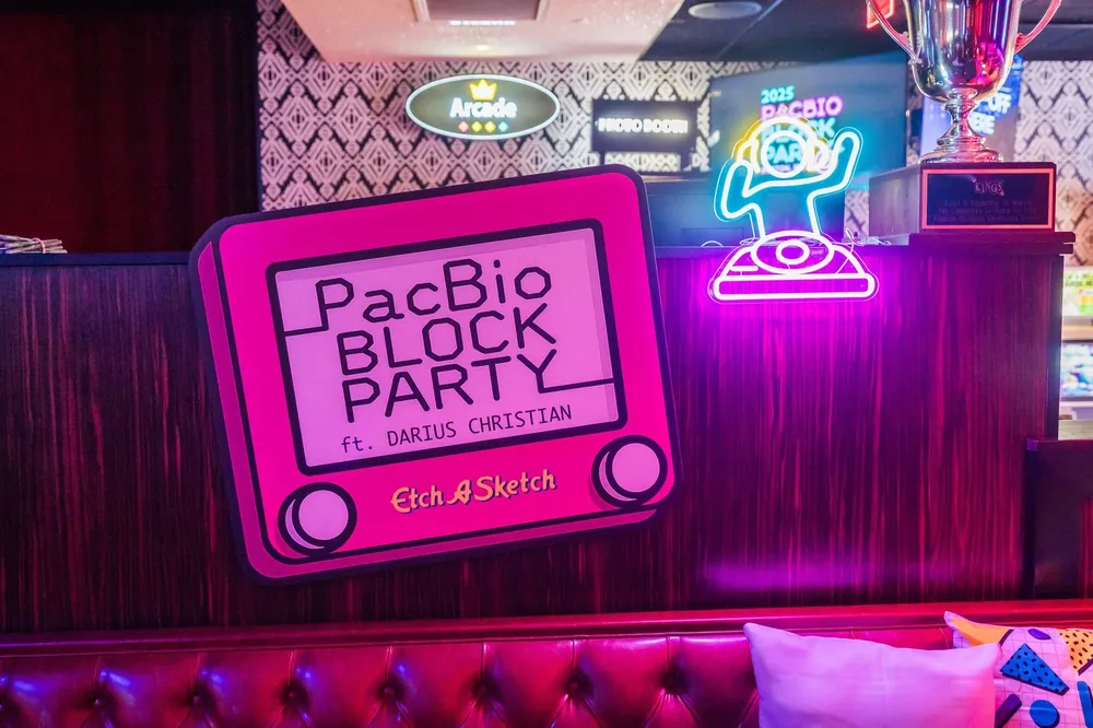 Neon sign for PacBio Block Party with TV featuring Darius Christian