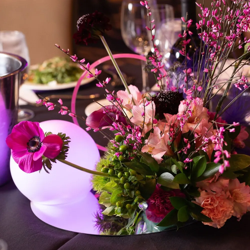 Floral centerpiece with pink, purple flowers and a glowing white orb