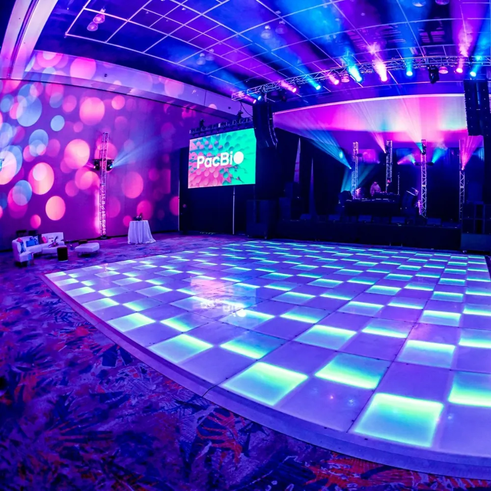 Lit dance floor with DJ booth and PacBio branding