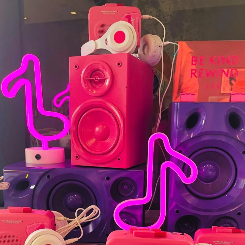 Retro 'Be Kind Rewind' theme with pink neon speakers and headphones