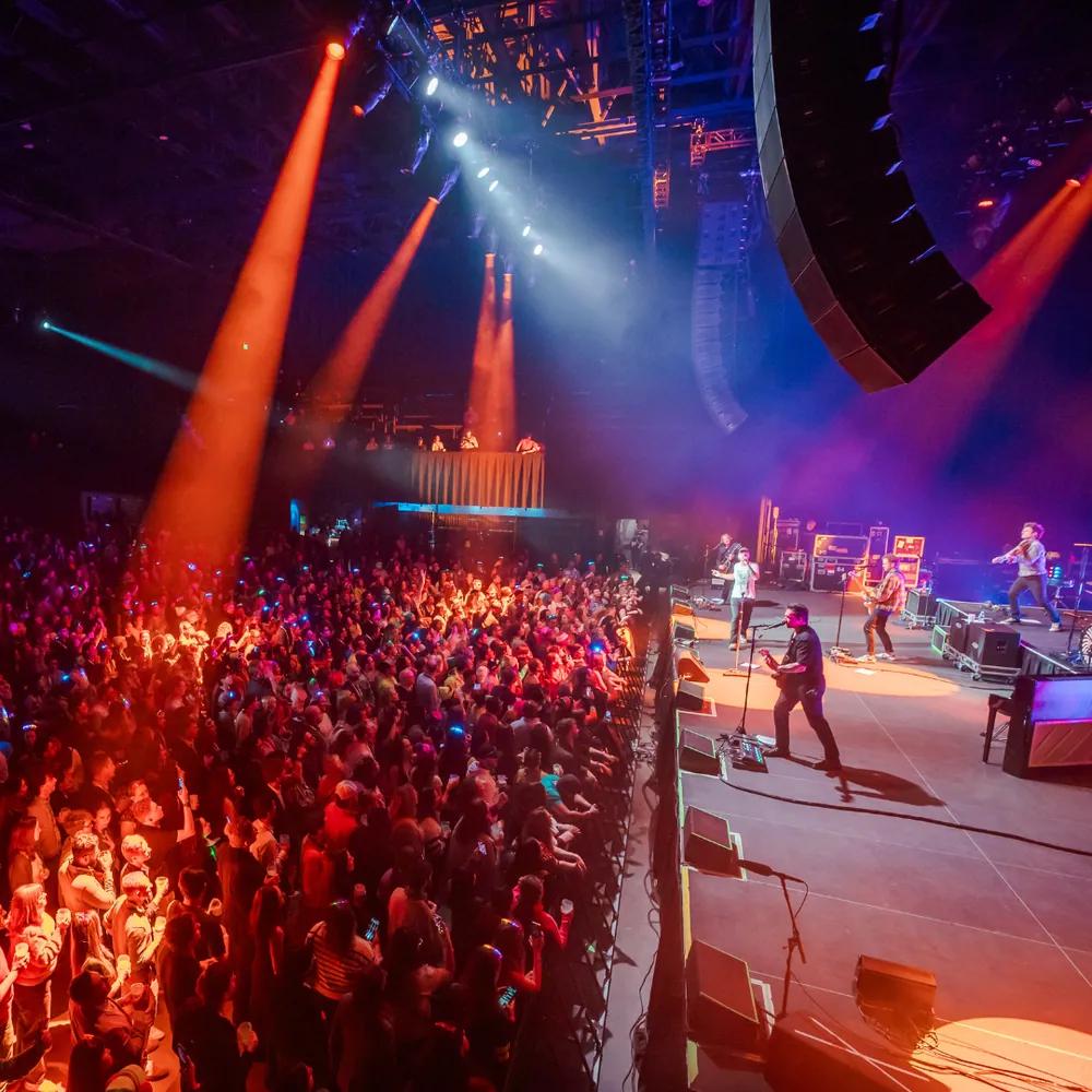 Concert audience with colorful stage lighting and OneRepublic on stage